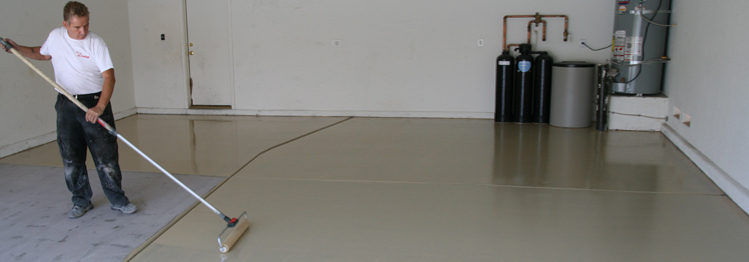 This image shows a man painting a floor with a roller brush.