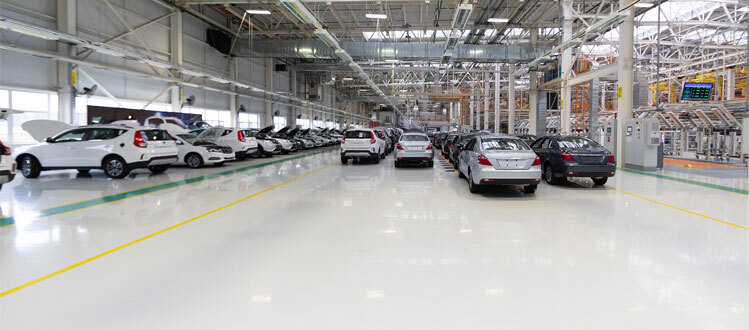 This image shows a car manufacturing plant with a white epoxy floor.