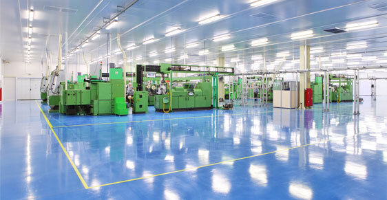 Industrial Epoxy Floor Coating Contractors This image shows an industrial plant that has an epoxy floor. The floor's colors are blue and grey with yellow lines in between them.