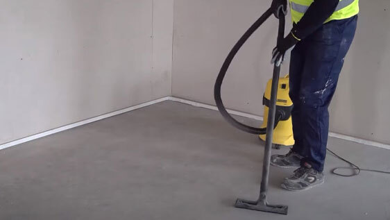 This image shows a woman using a vacuum to clean a floor.